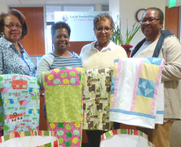 People holding quilts