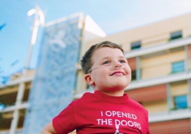 Six-year-old heart patient in front of hospital
