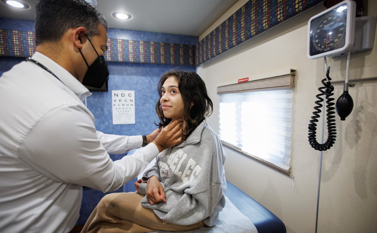 A girl gets a medical check up by a doctor inside the Teen Van.
